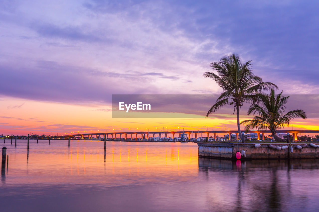 Scenic view of sea against cloudy sky during sunset