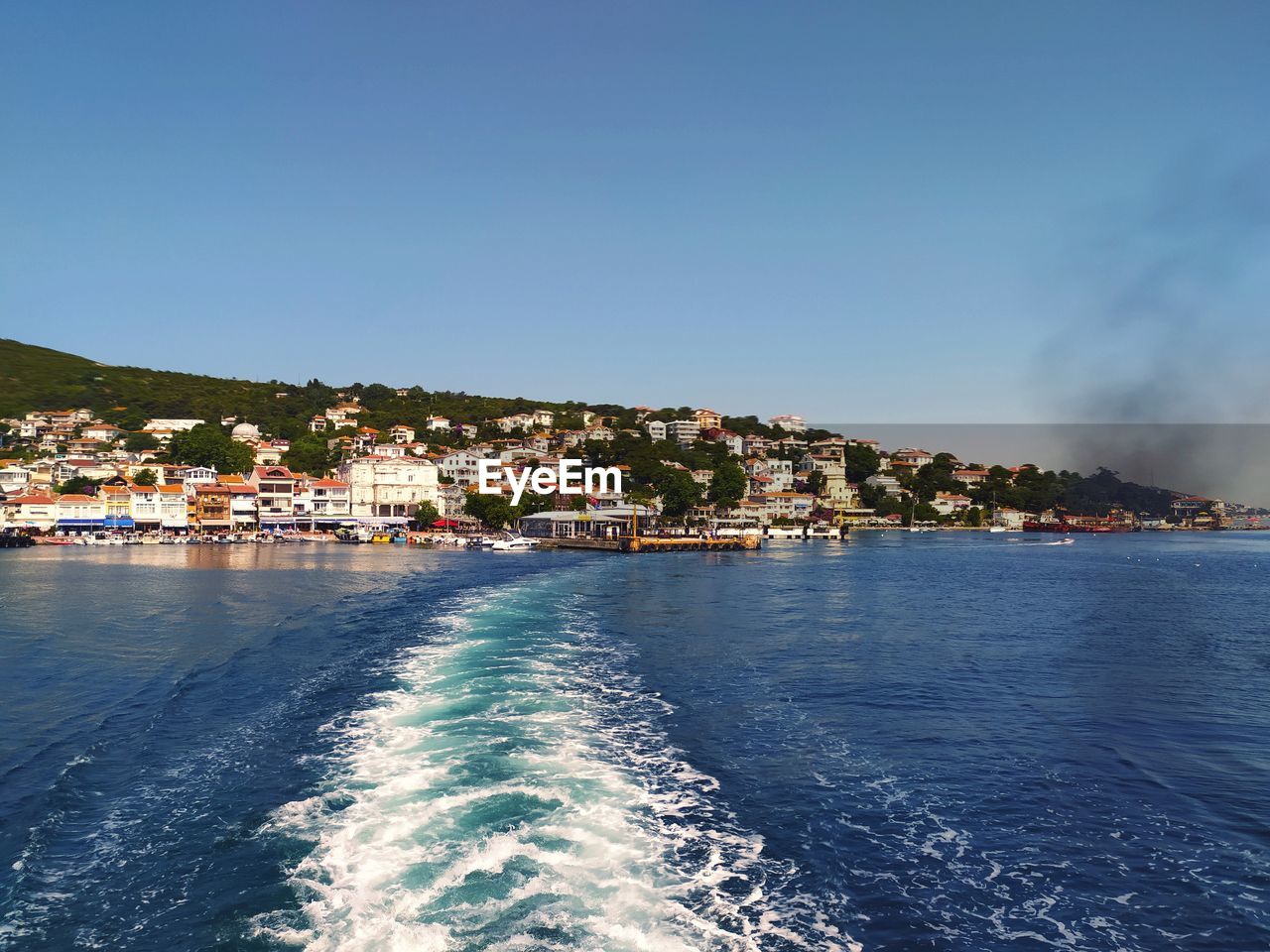 Scenic view of sea by buildings against sky