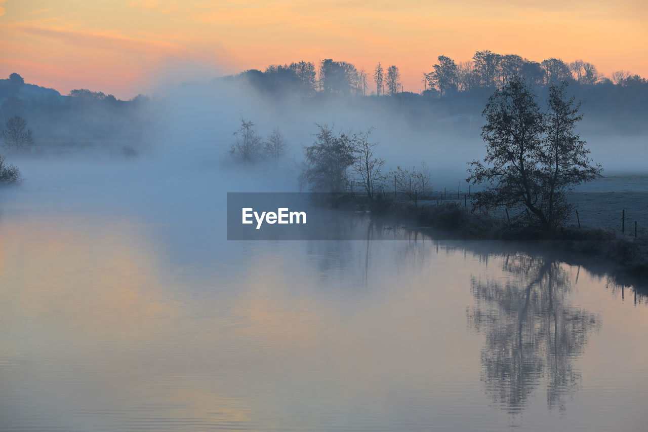 Scenic view of lake against sky during sunset