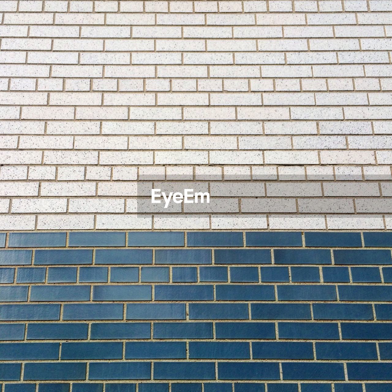 FULL FRAME SHOT OF BRICK WALL WITH BUILDING