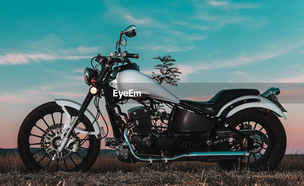 Motorcycle parked on land against sky