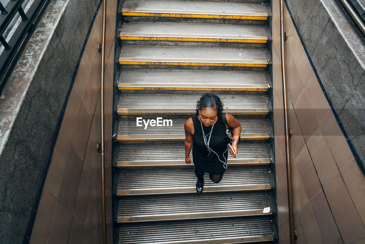 HIGH ANGLE VIEW OF WOMAN ON STAIRS