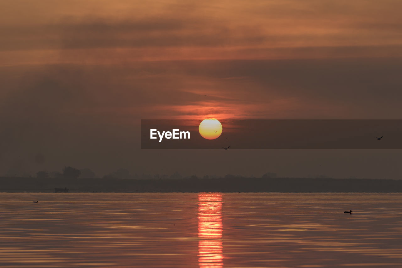 SCENIC VIEW OF SUNSET OVER SEA