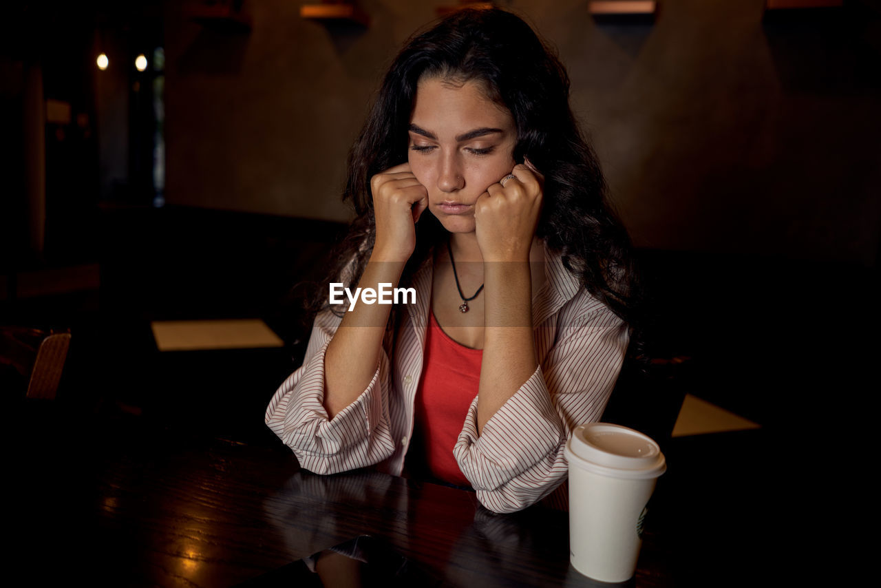 young woman using mobile phone while sitting at home