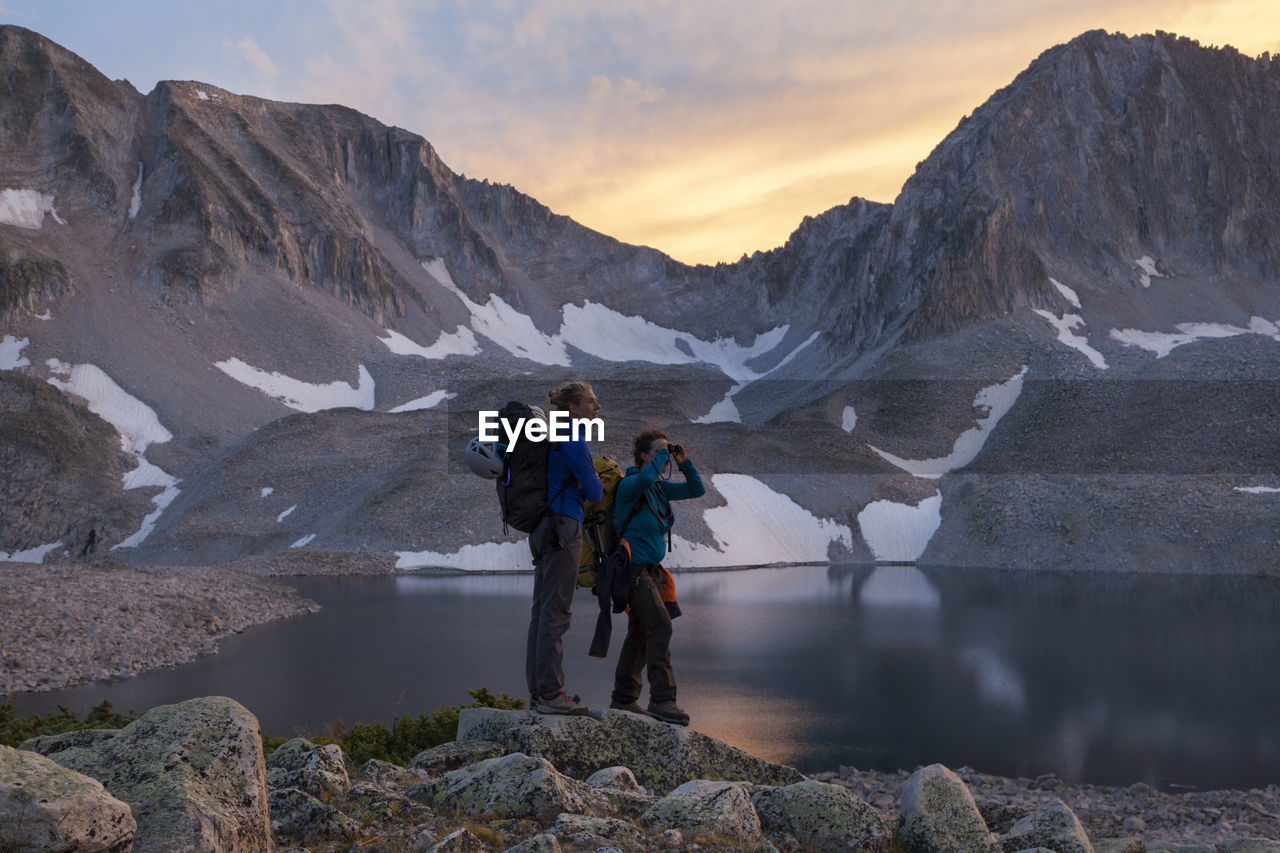 Women hikers watch sunset from pierre lakes, elk mountains, colorado