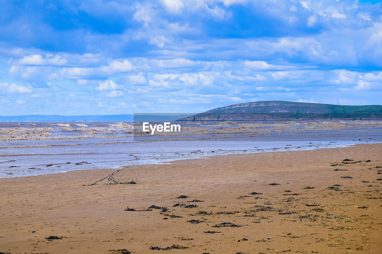 SCENIC VIEW OF BEACH AGAINST CLOUDY SKY