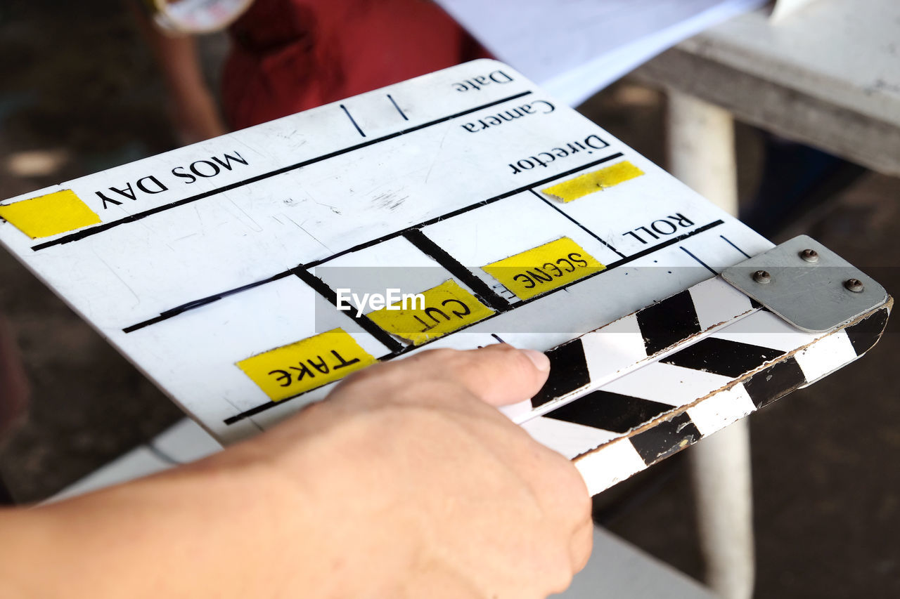 Close-up of cropped hands above film slate