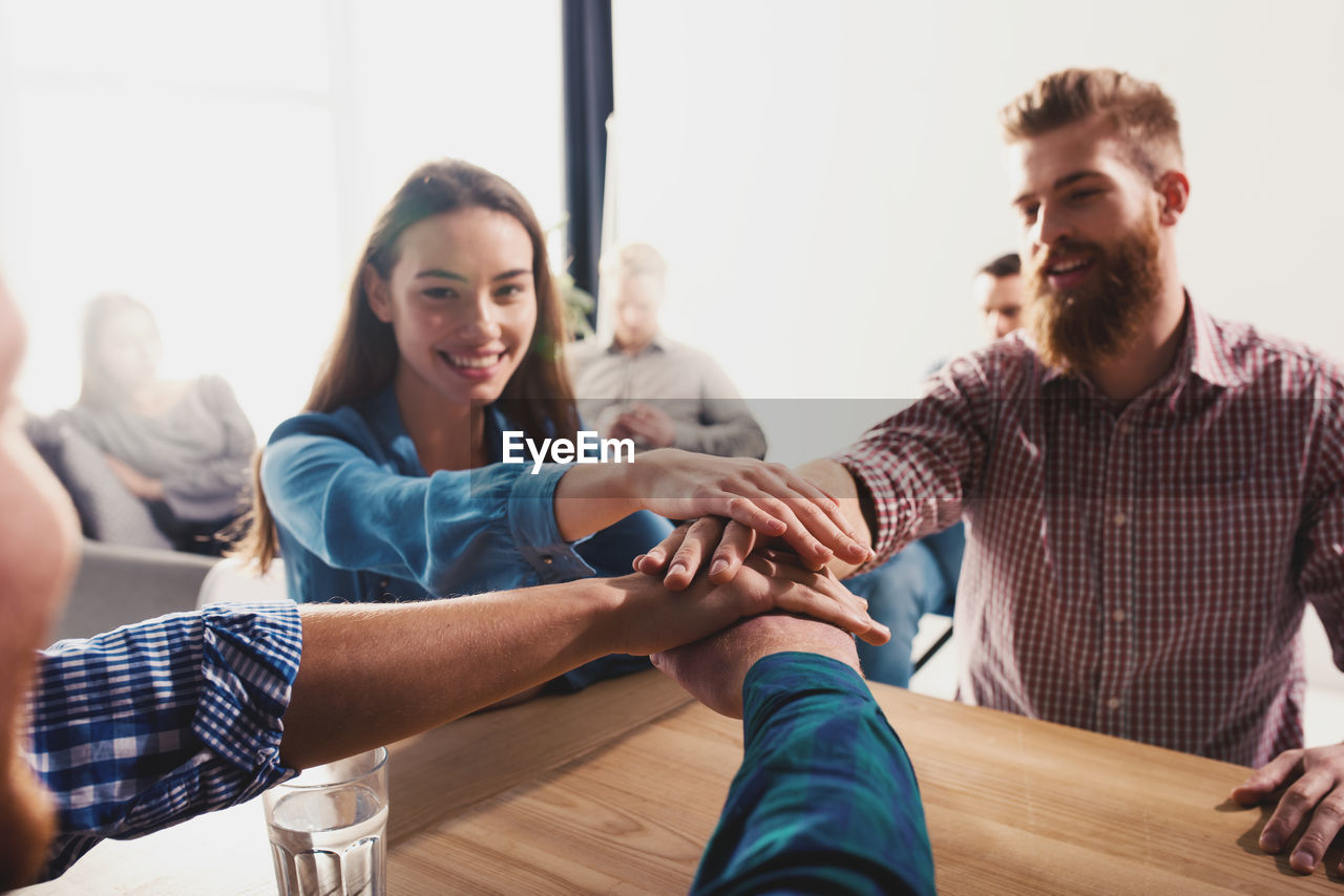 Business people stacking hands at office