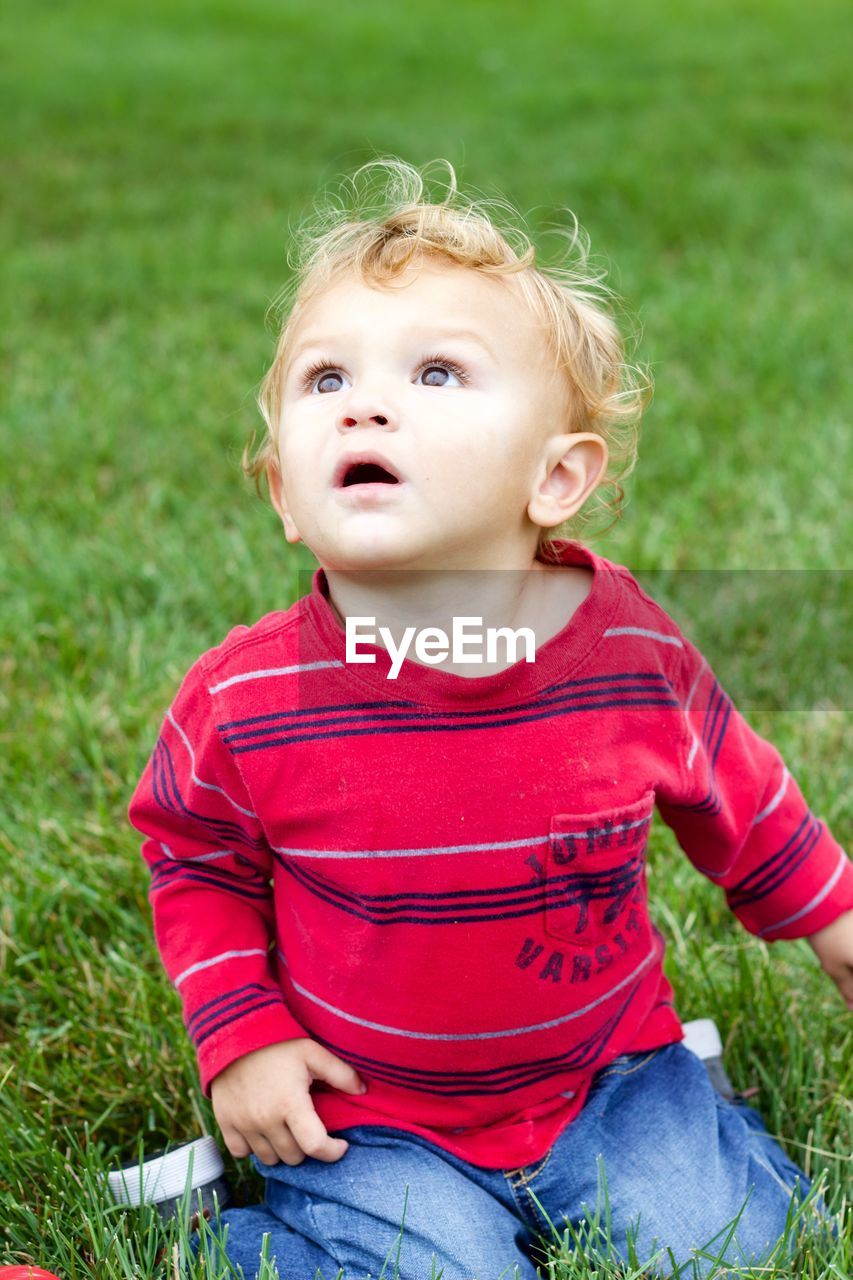 Cute boy sitting on grass