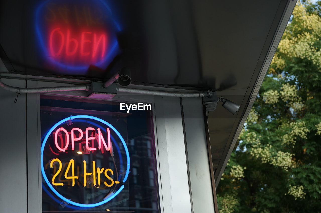 Low angle view of illuminated information sign on window