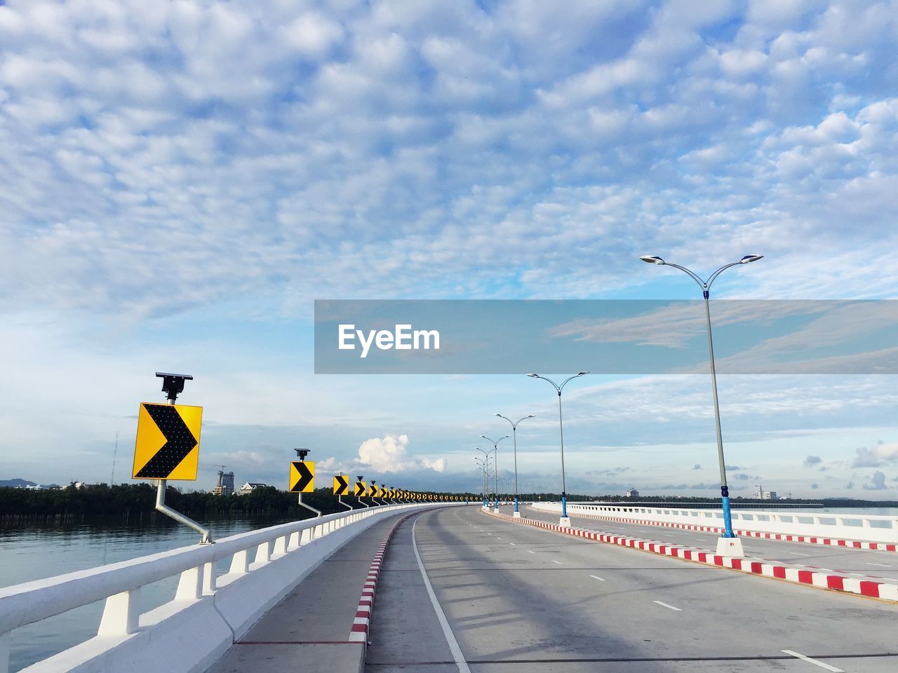 Road sign on bridge against sky