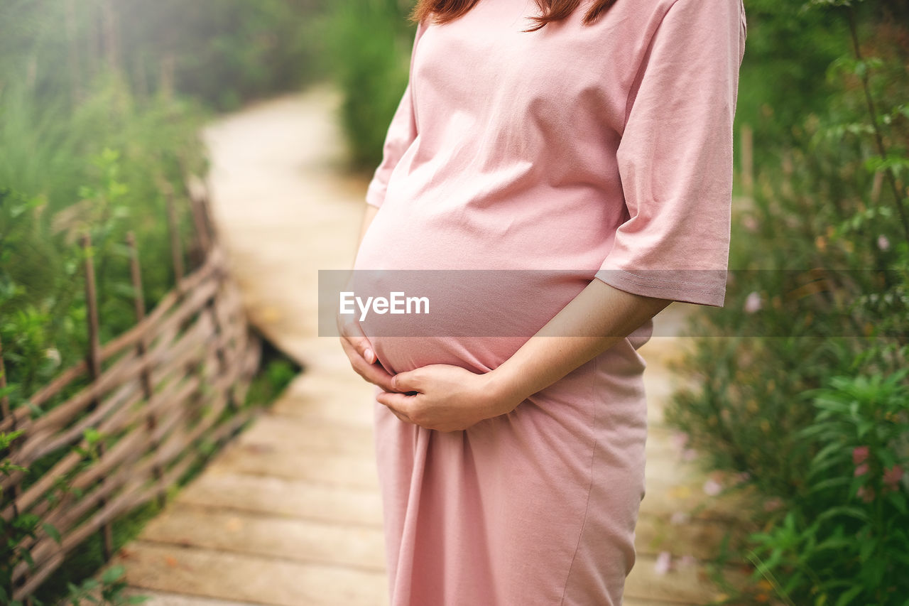 MIDSECTION OF WOMAN TOUCHING HEAD