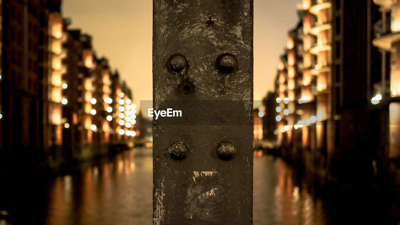 Close-up of metallic object with canal in background