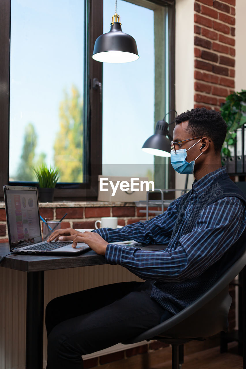 Businessman working in office during pandemic