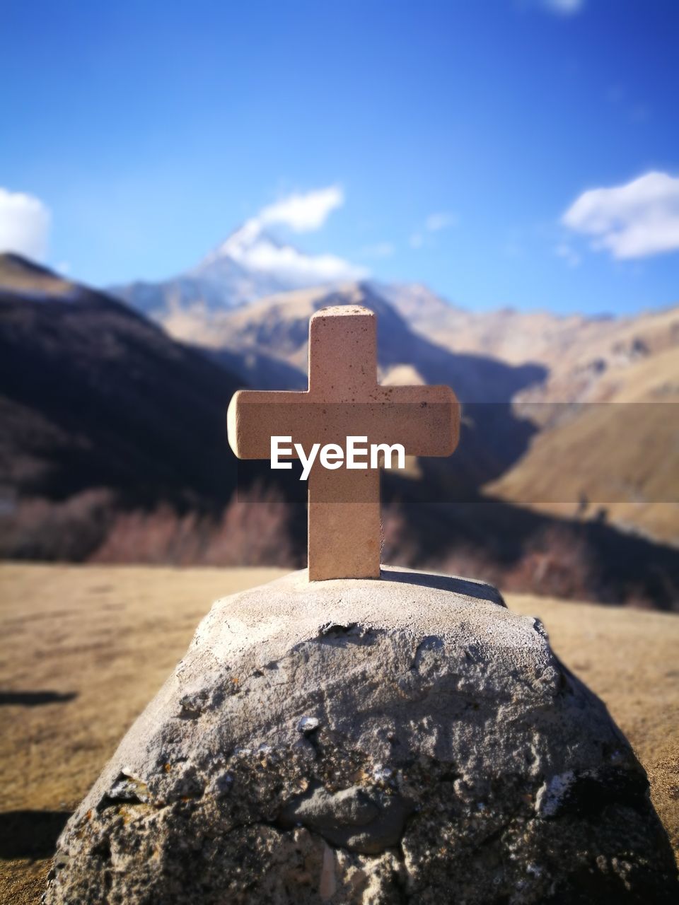 Close-up of cross on mountain against sky