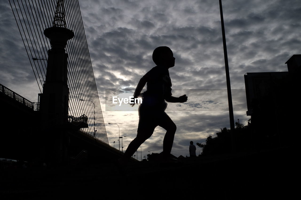 LOW ANGLE VIEW OF SILHOUETTE WOMAN AGAINST SKY