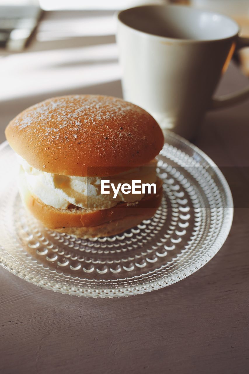 Close-up of coffee served on table with a bun called semla 