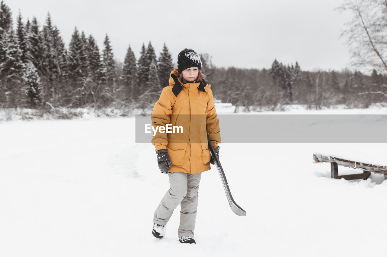 Cute teenage girl rides a snowskate in a winter park, healthy lifestyle