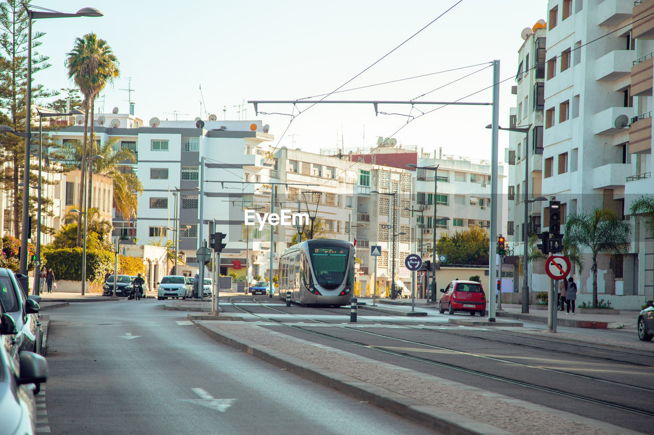 VEHICLES ON ROAD ALONG BUILDINGS