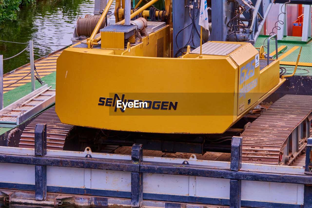 HIGH ANGLE VIEW OF YELLOW CONSTRUCTION SITE BY BUILDINGS