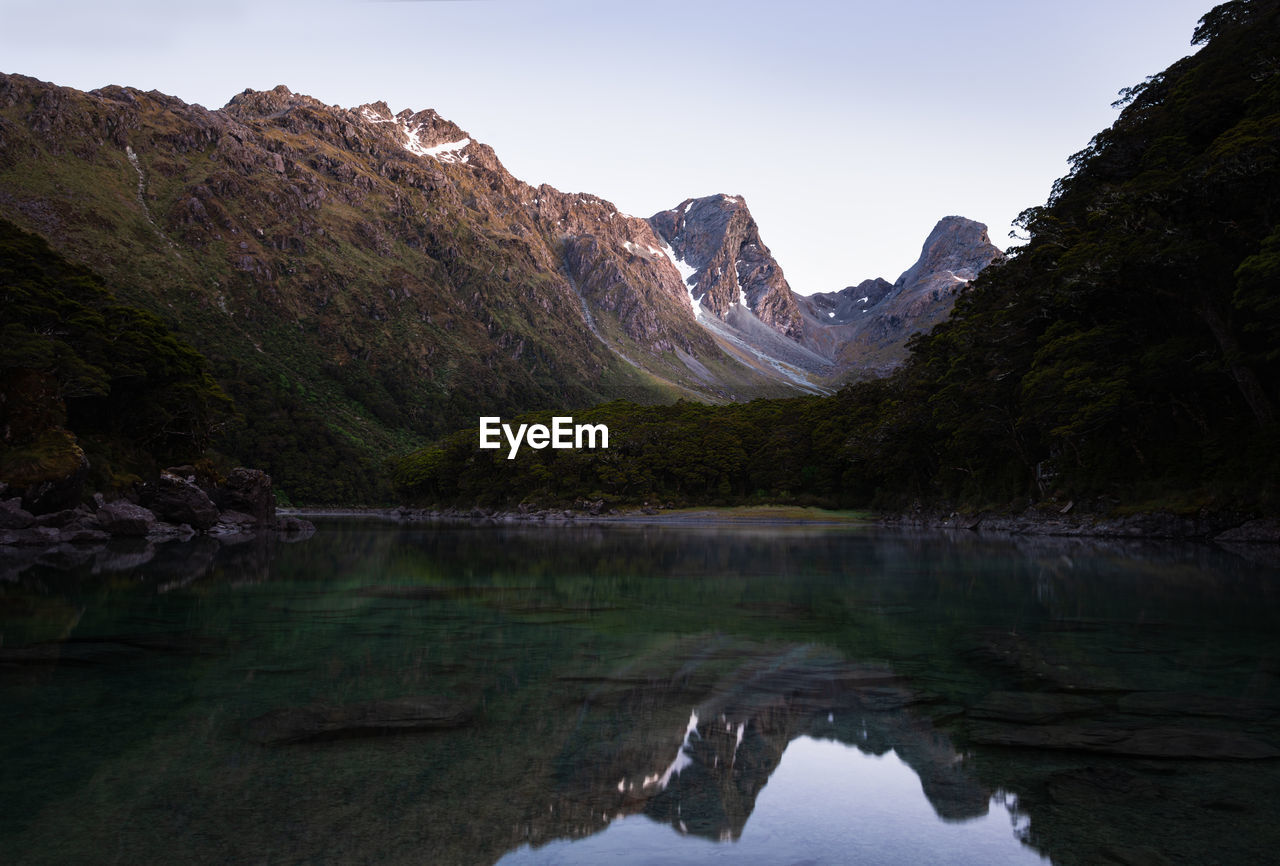 SCENIC VIEW OF LAKE AGAINST MOUNTAIN RANGE