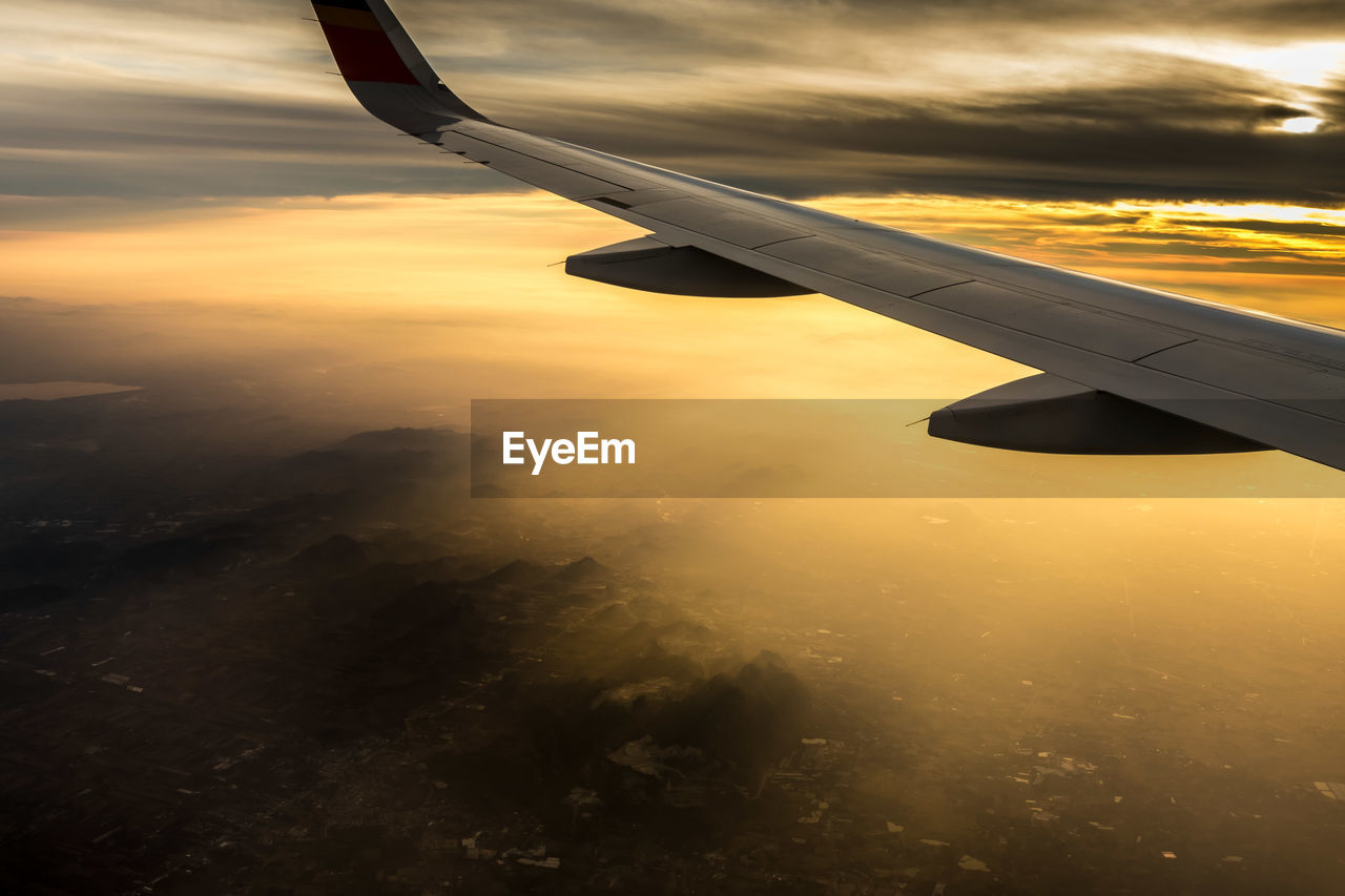 CLOSE-UP OF AIRPLANE WING OVER CLOUDS