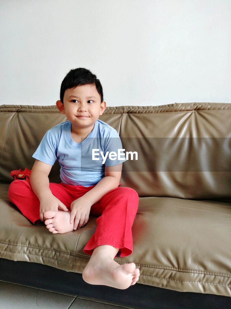 Smiling boy sitting on sofa at home