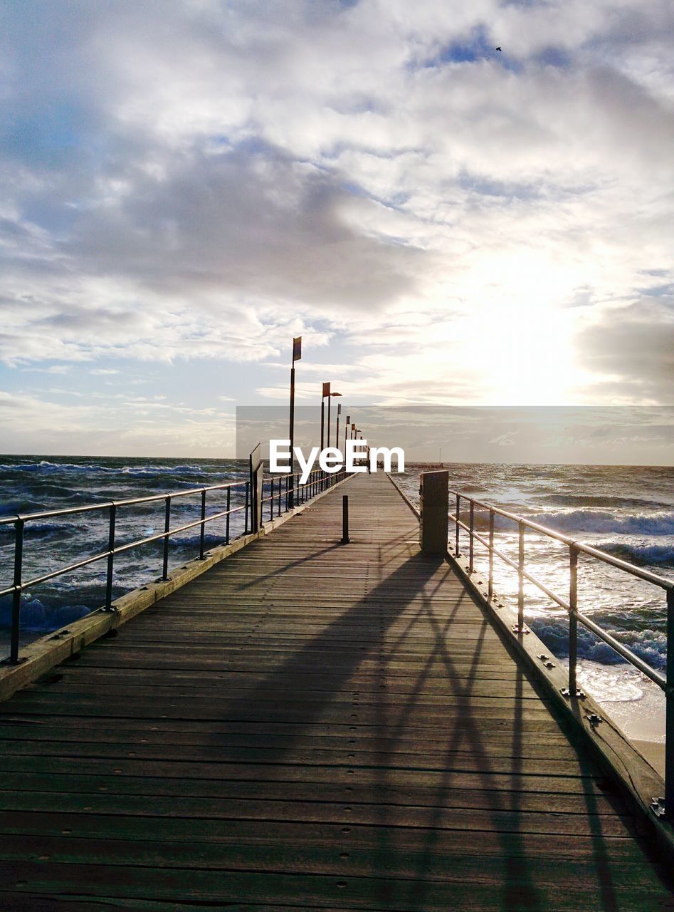 Pier on sea at sunset