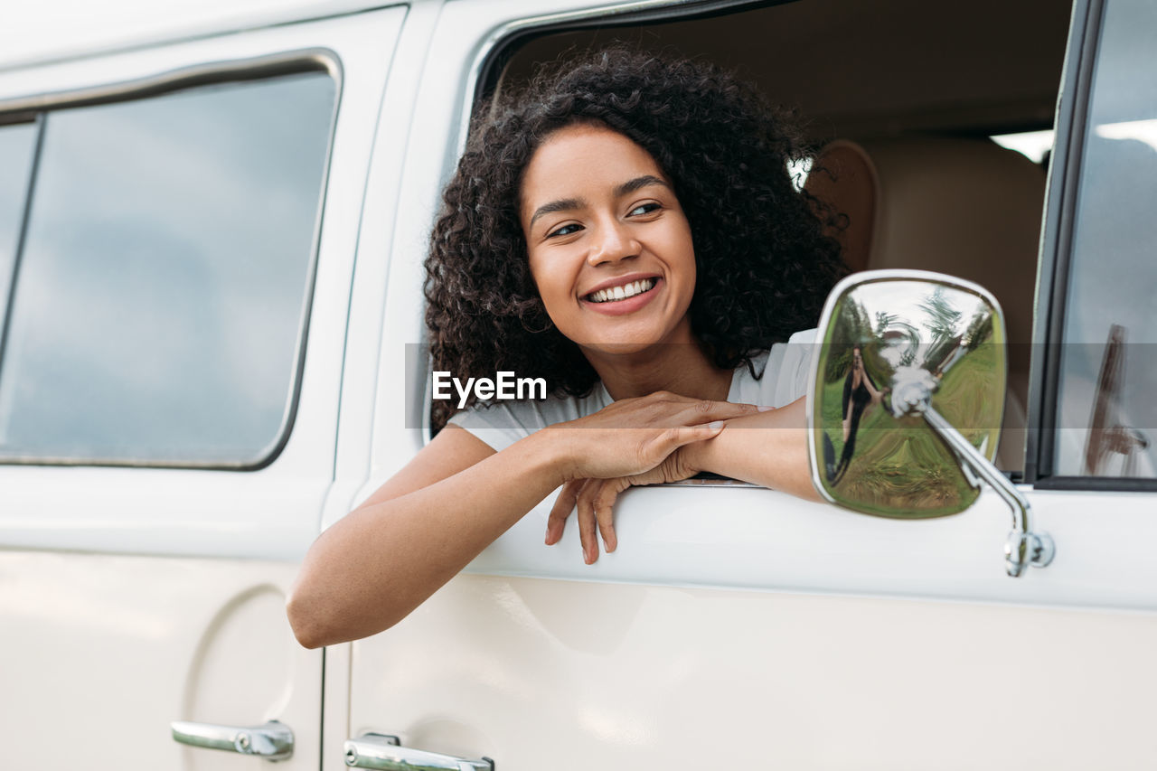 Portrait of smiling woman sitting in car