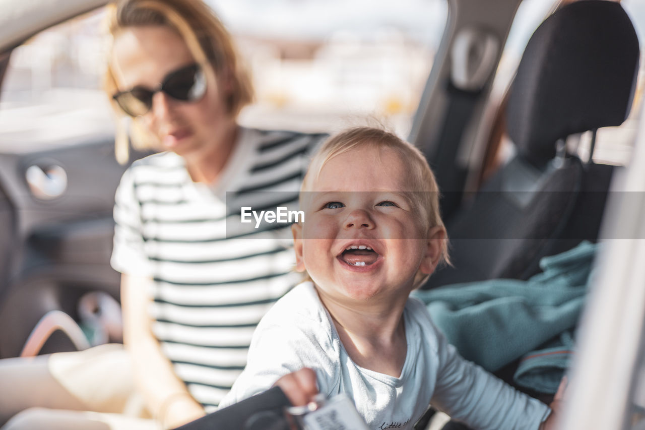 portrait of smiling young woman sitting in car