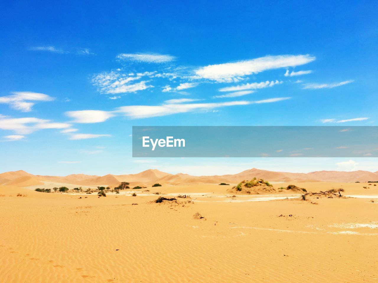 Scenic view of desert against blue sky