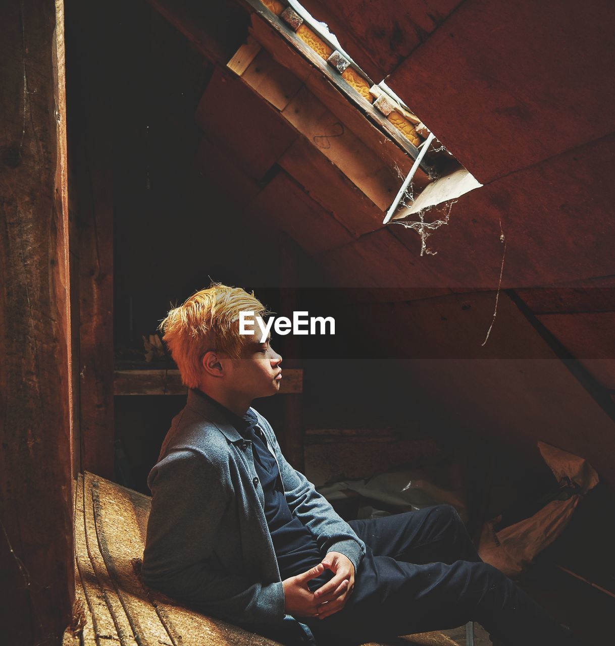 Full length of young man resting against roof