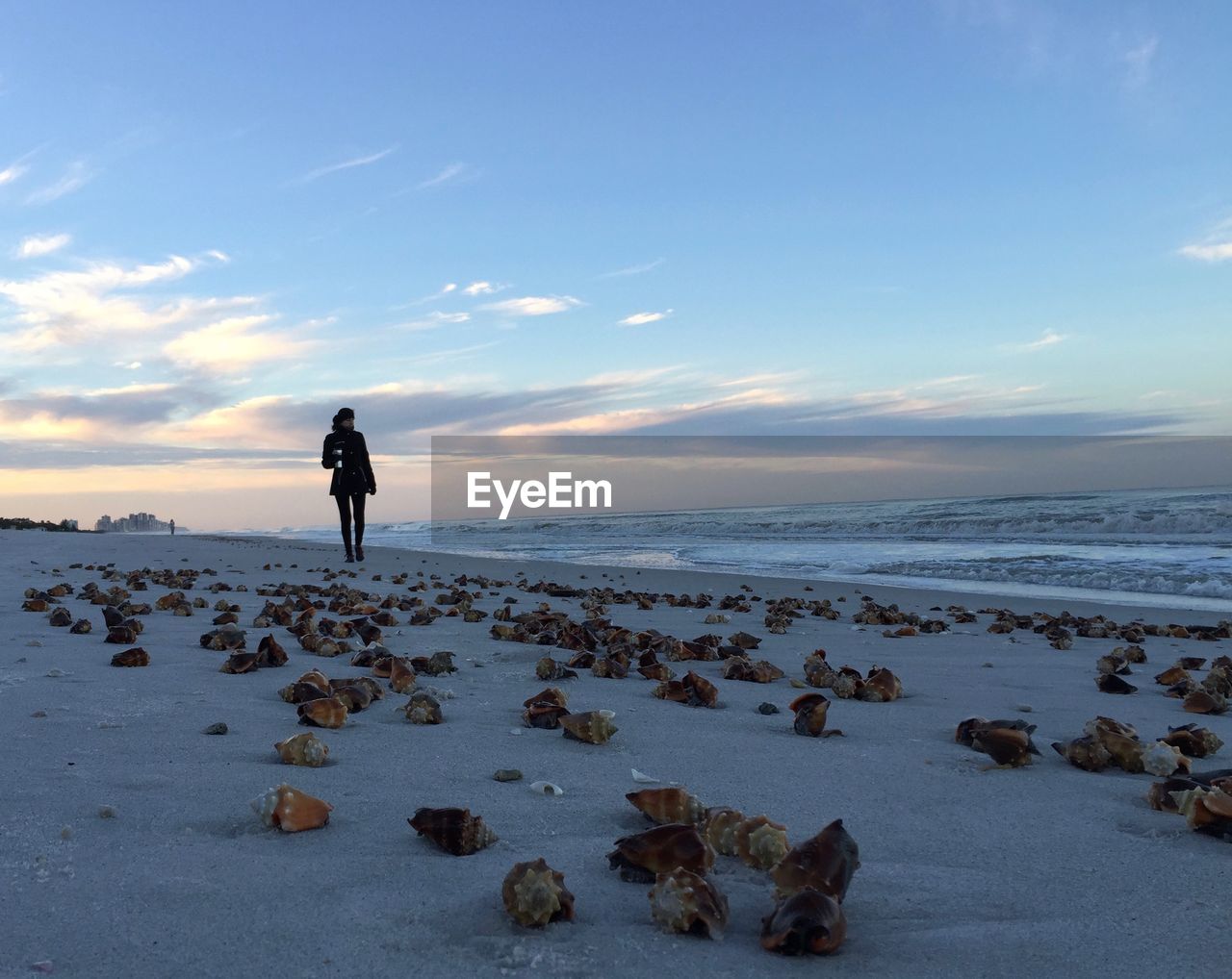 WOMAN STANDING ON BEACH