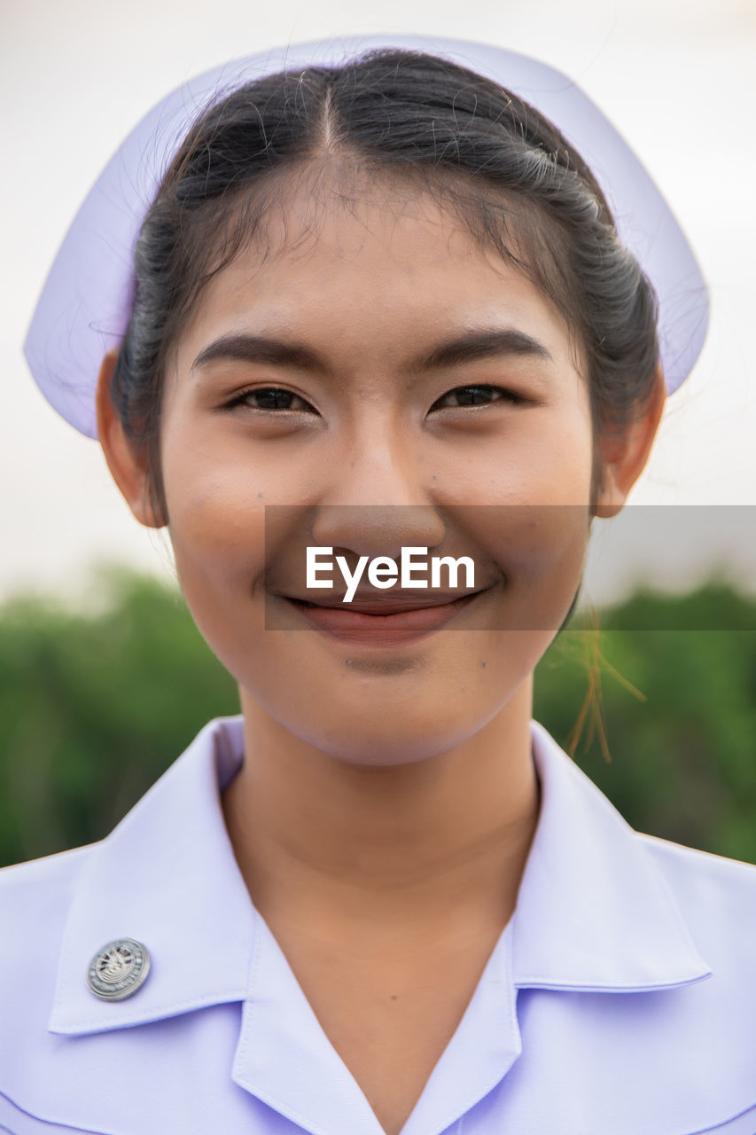 Smiling young nurse on field