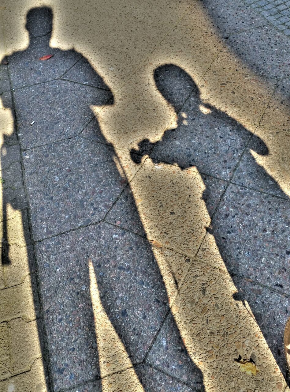 SHADOW OF PERSON ON ROAD