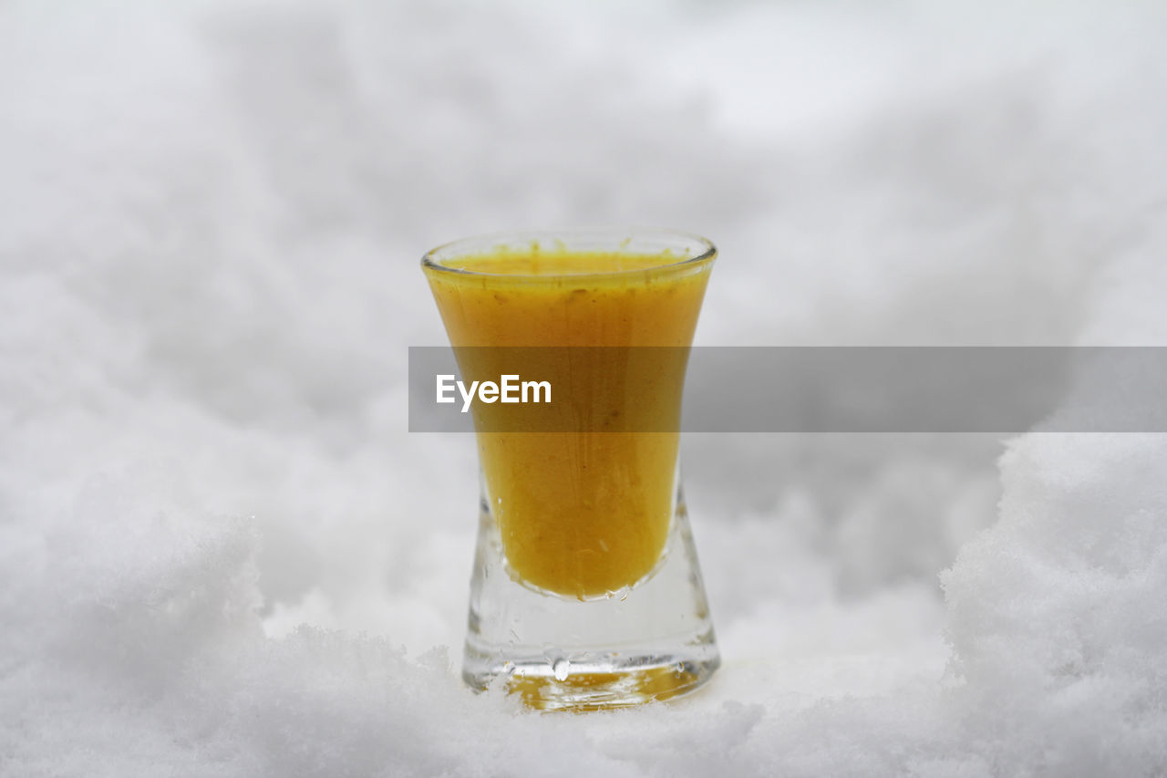 CLOSE-UP OF YELLOW JUICE ON TABLE