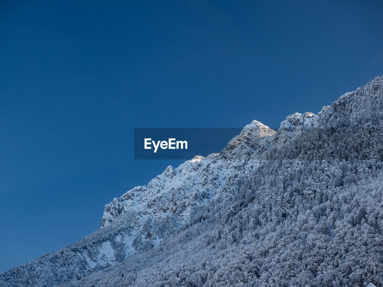 snow, cold temperature, mountain, winter, sky, mountain range, scenics - nature, blue, beauty in nature, environment, nature, landscape, clear sky, no people, ridge, summit, tranquility, day, tranquil scene, snowcapped mountain, frozen, outdoors, copy space, travel destinations, non-urban scene, mountain peak, ice, land, sunny, travel, rock, plateau