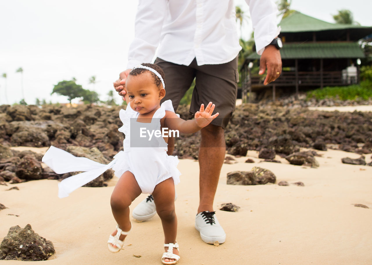 REAR VIEW OF FATHER AND SON ON BEACH