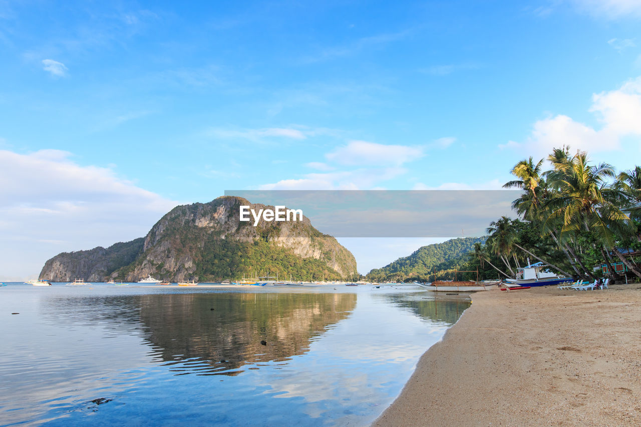 View of calm beach against blue sky