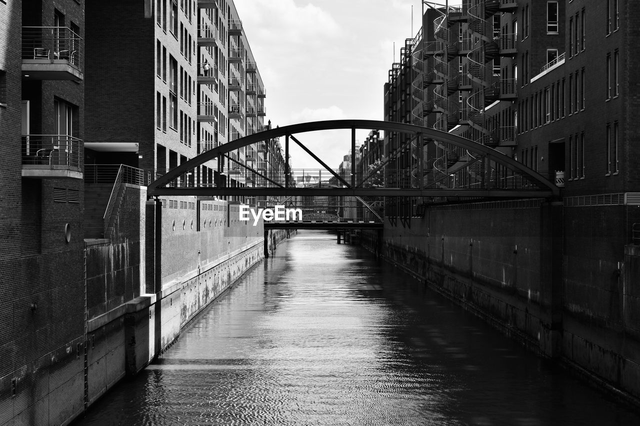 BRIDGE OVER RIVER BY BUILDINGS IN CITY