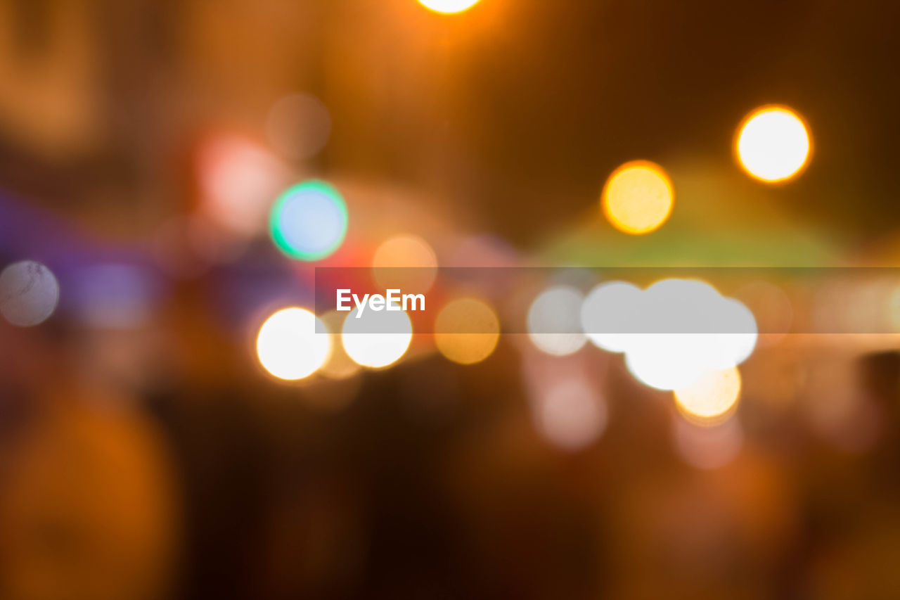 DEFOCUSED IMAGE OF ILLUMINATED LIGHTS AGAINST SKY