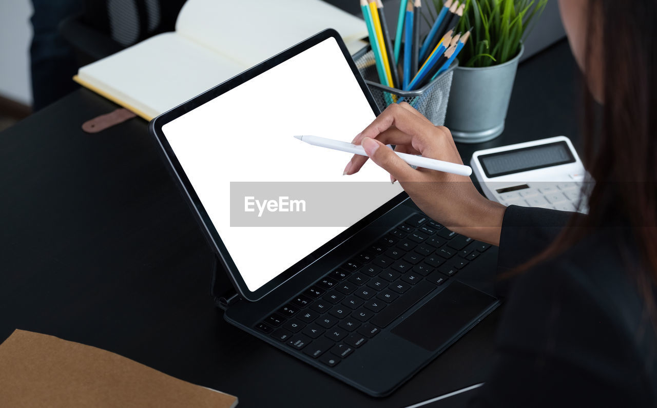 LOW ANGLE VIEW OF PERSON USING MOBILE PHONE IN RESTAURANT