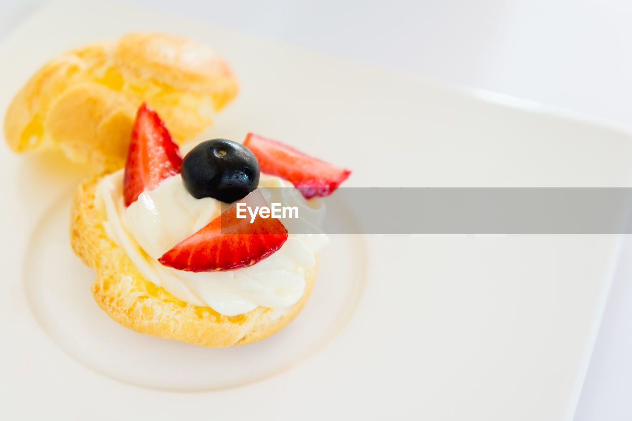 High angle view of dessert with garnishing of blueberry and strawberry