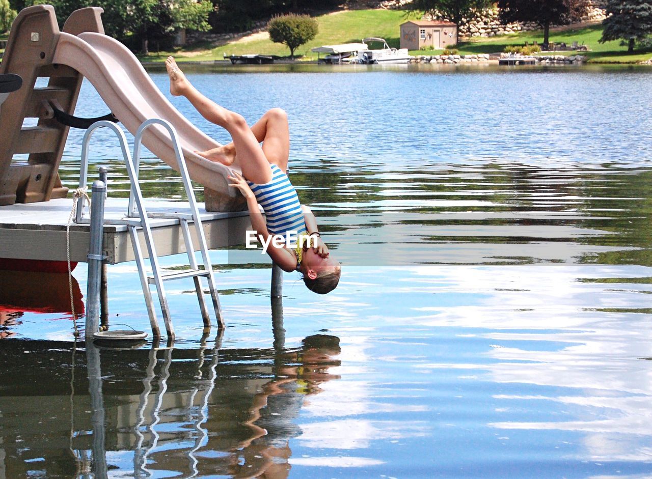 LOW SECTION OF YOUNG WOMAN ON LAKE