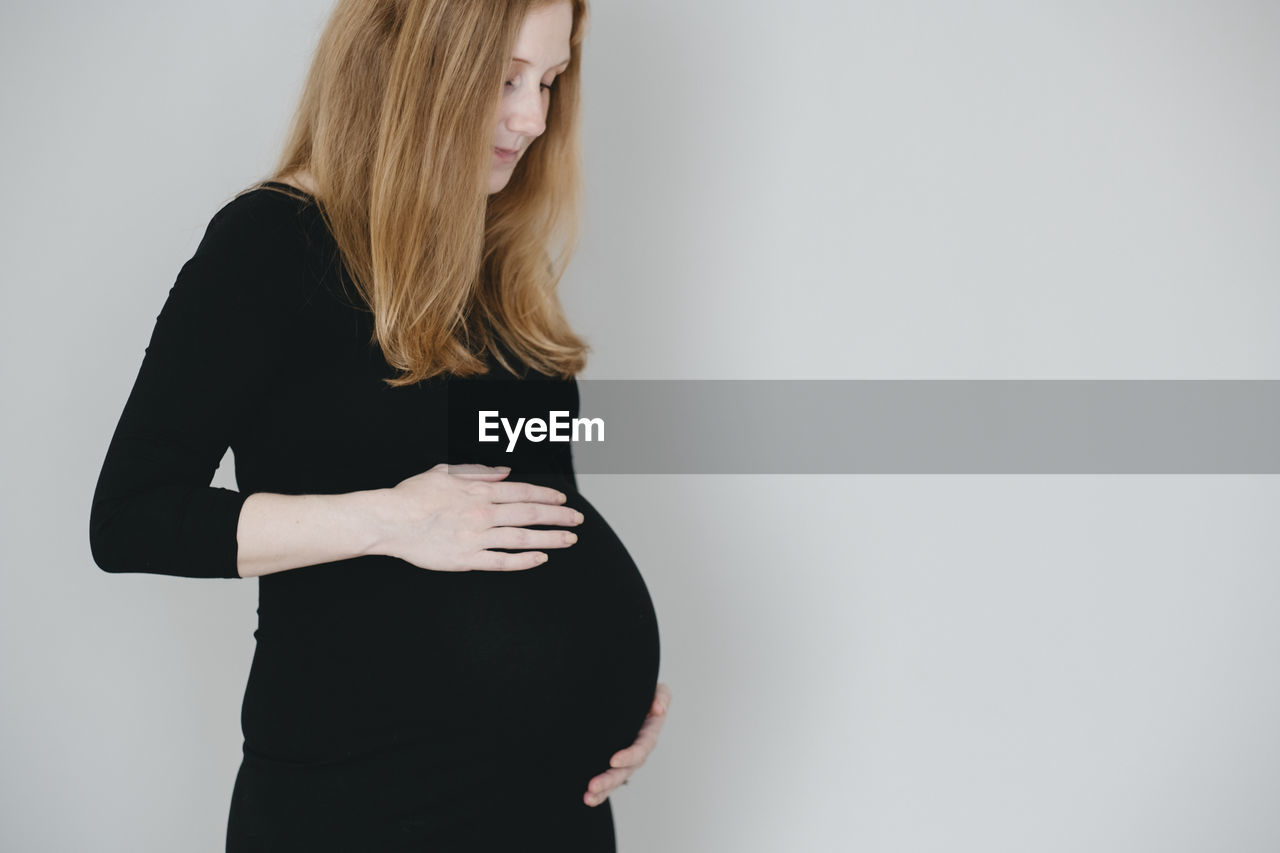 Pregnant woman with hands on belly