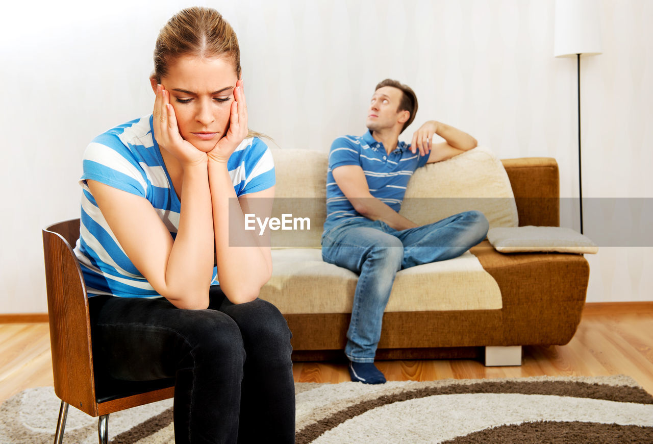 Tensed couple sitting at home