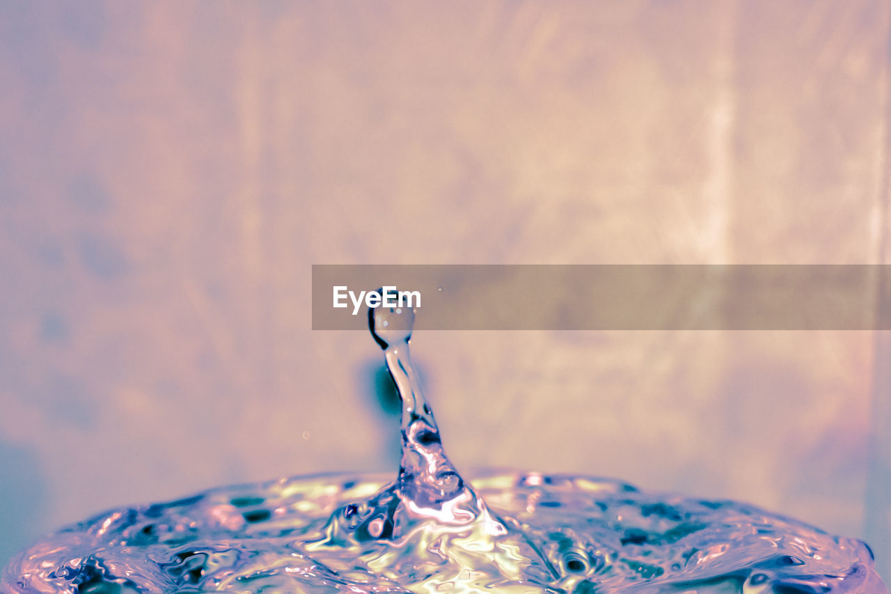 CLOSE-UP OF WATER SPLASHING IN CONTAINER