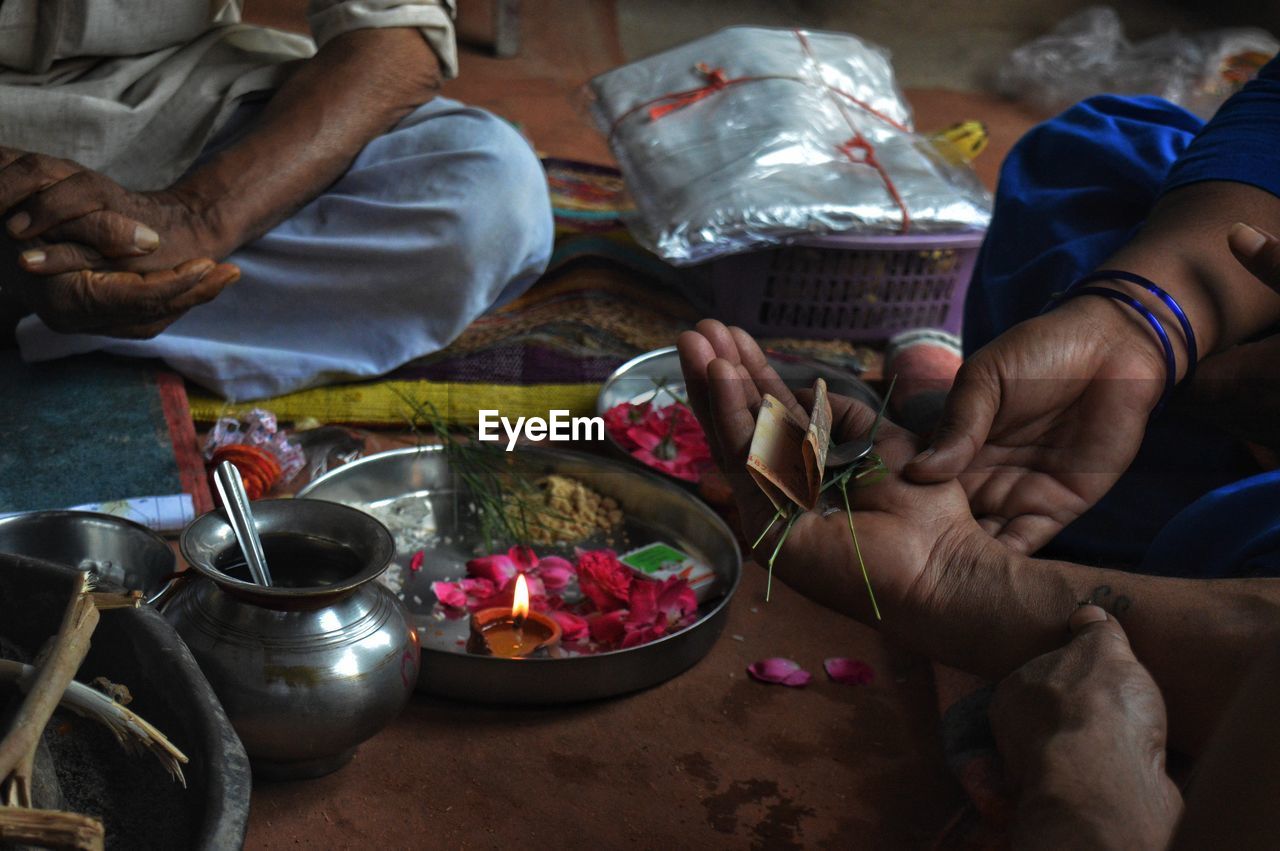 High angle view of people holding religious offerings and paper currency