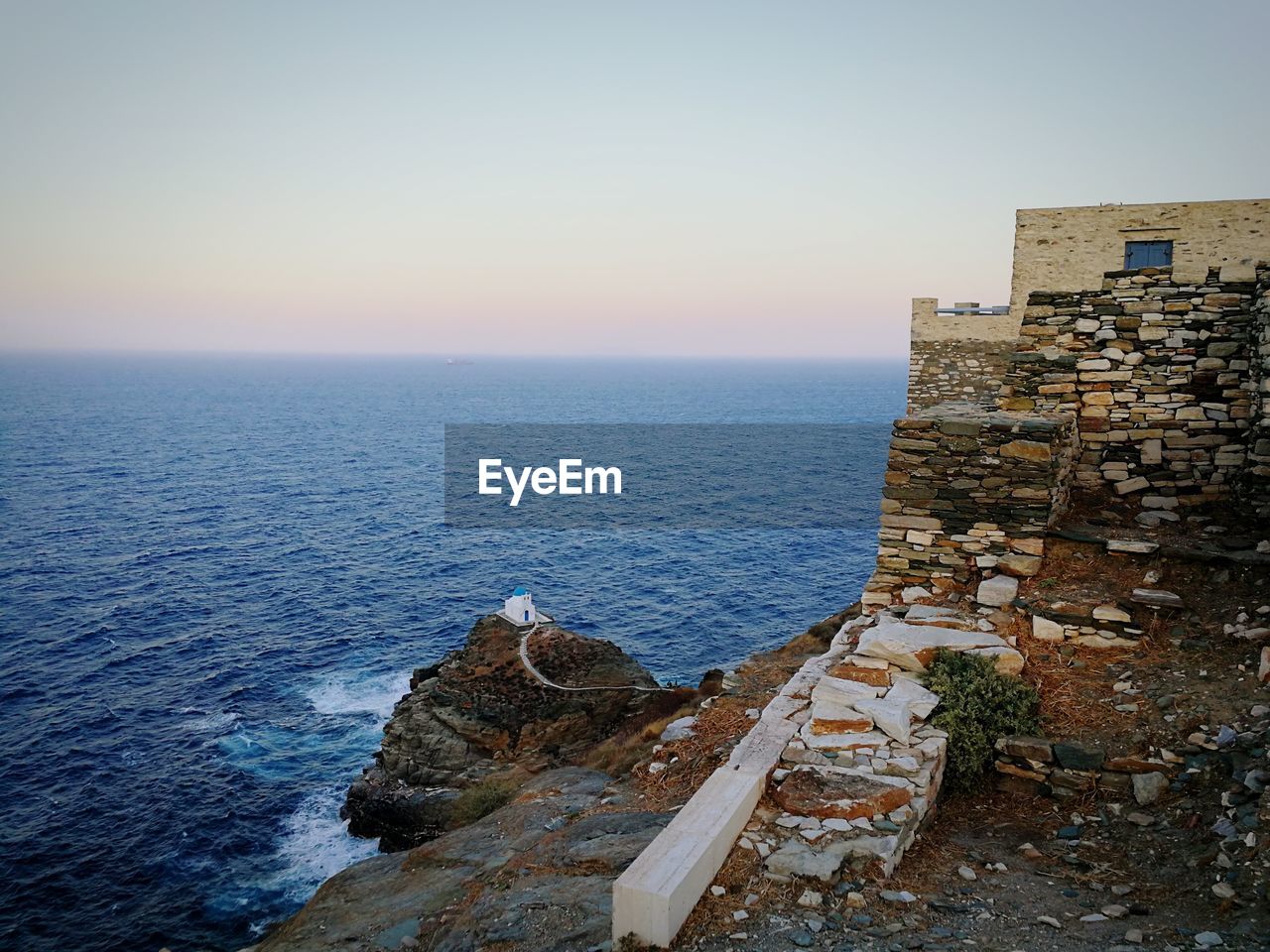 SCENIC VIEW OF SEA AND ROCKS AGAINST CLEAR SKY