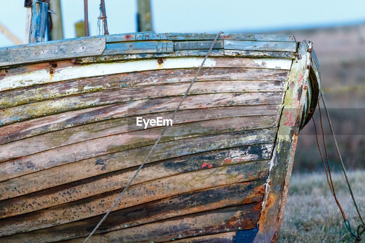 Close-up of abandoned boat on field